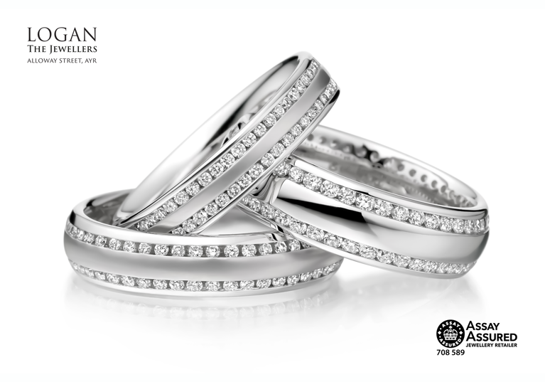 Three silver wedding bands with two thin bands of diamonds on each